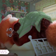 An oversized red panda huddles under a green blanket in a scene from Turning Red.